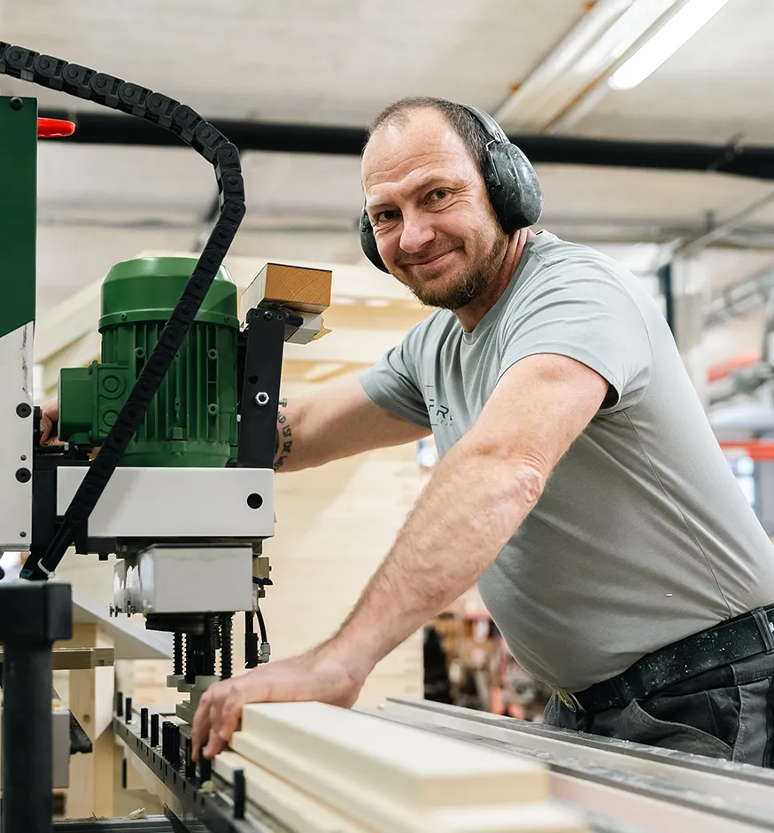 Mann arbeitet an einer Holzbearbeitungsmaschine in der Werkstatt.