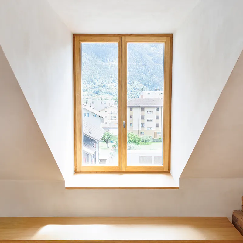 Helles Fenster im Dachgeschoss mit Blick auf die Stadt und Berge.