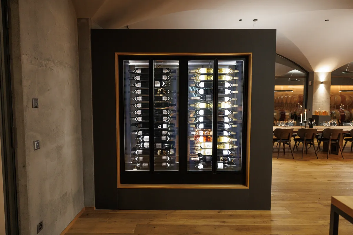 Weinlager mit schwarzen Rahmen und beleuchteten Flaschen in Restaurant.