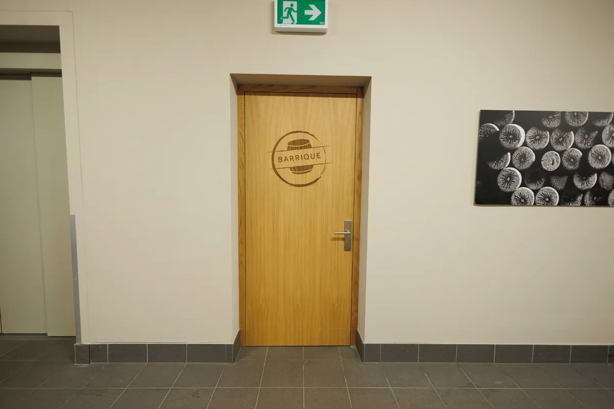 Holztür mit Barrique-Logo in einem Gebäude im Oberwallis.