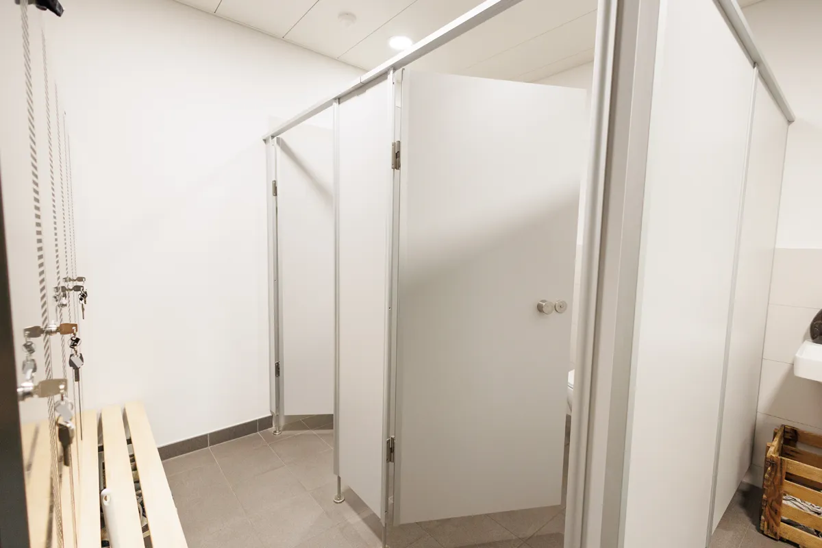 Weiße WC-Kabinen in einem öffentlichen Sanitärraum im Oberwallis.